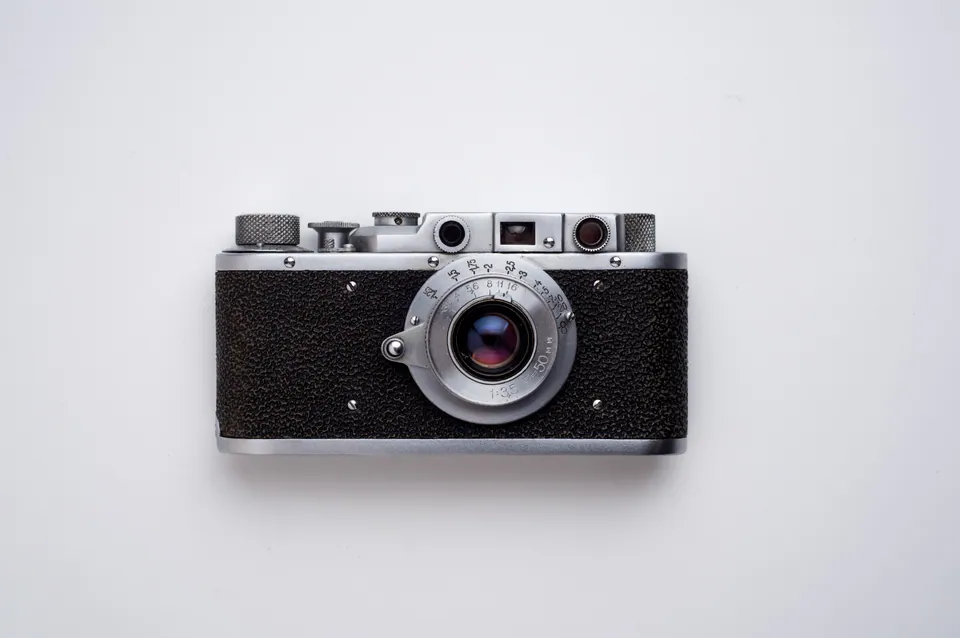 Silver and black camera on a pale background