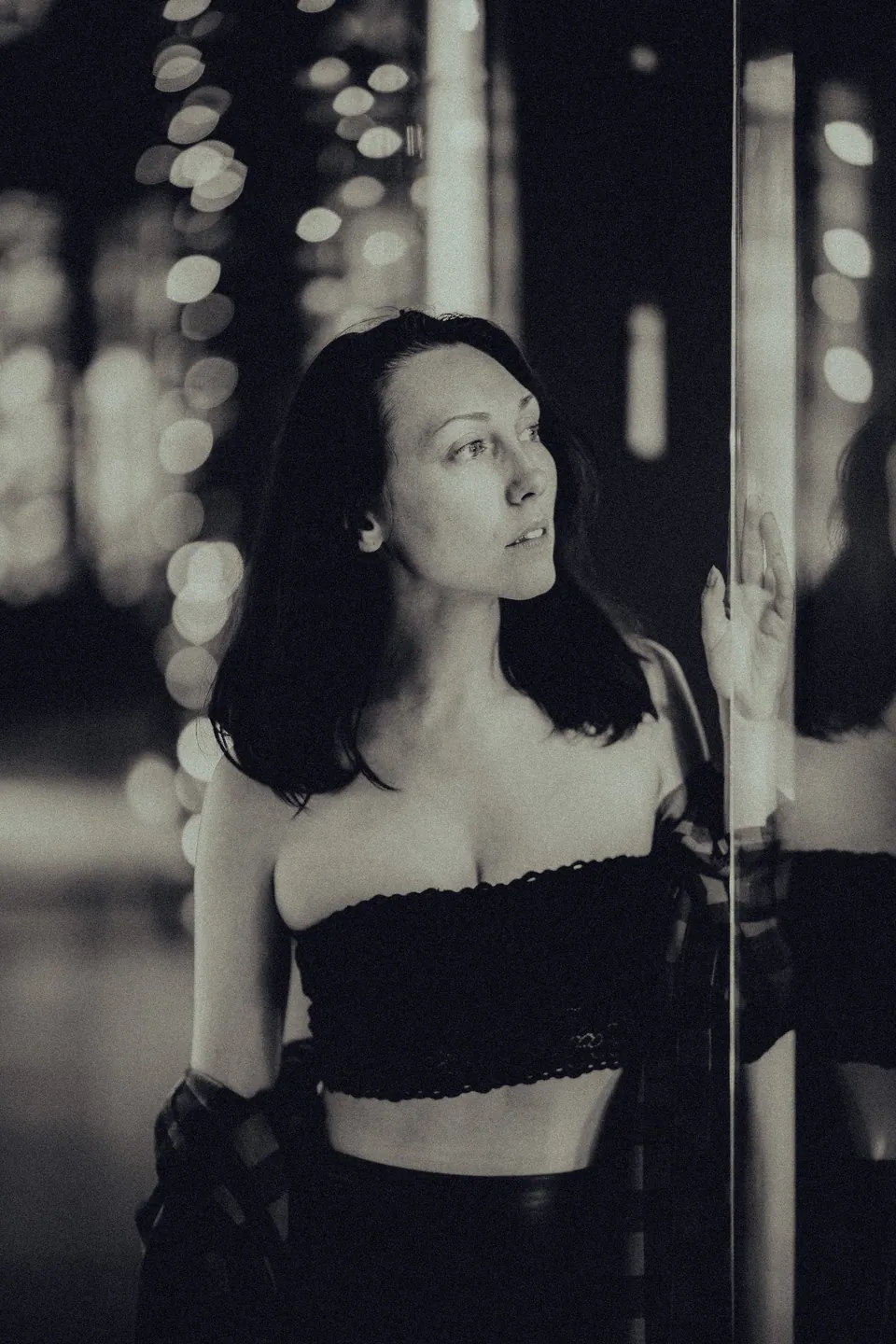 Black-and-white portrait beside glass with reflected lights
