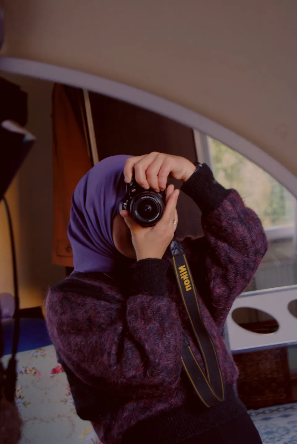 Photographer holding a camera in front of a mirror