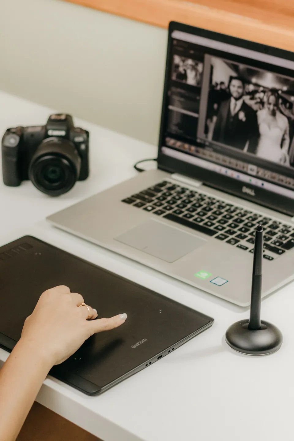 Photo-editing workspace with a laptop, camera, and drawing tablet