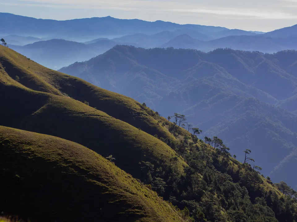 Green mountain ridges beneath a blue sky