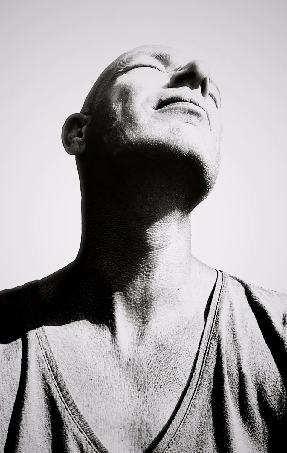 Black-and-white portrait of a man looking up into the light