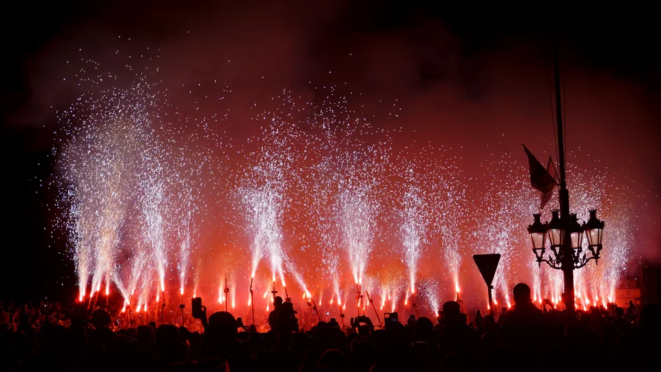 Fireworks illuminating the sky above a crowd at night