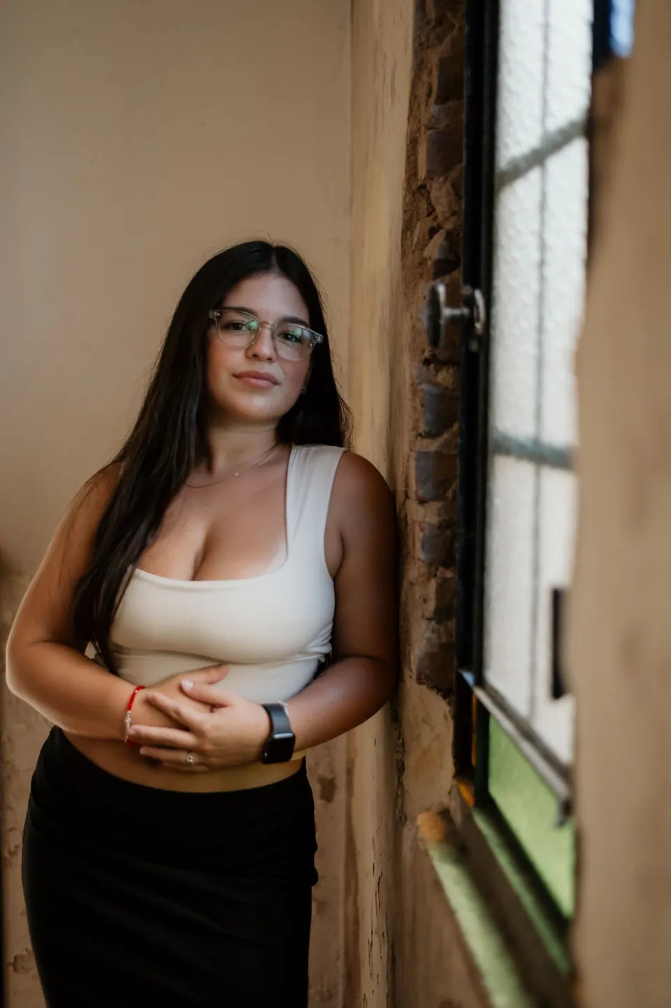 Woman standing beside a window in a softly lit room